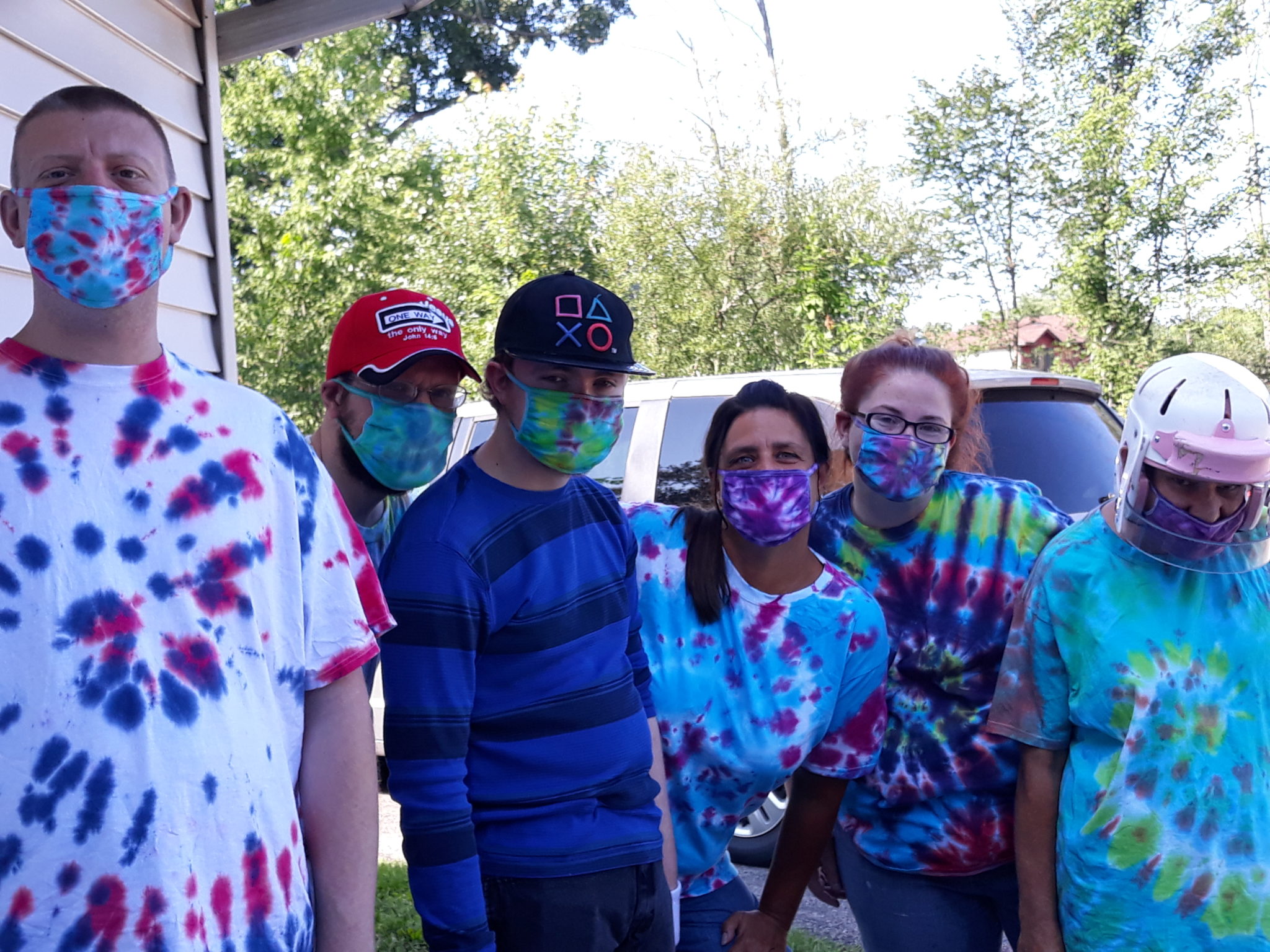 A group of people we support showing off their tie dyed masks and shirts