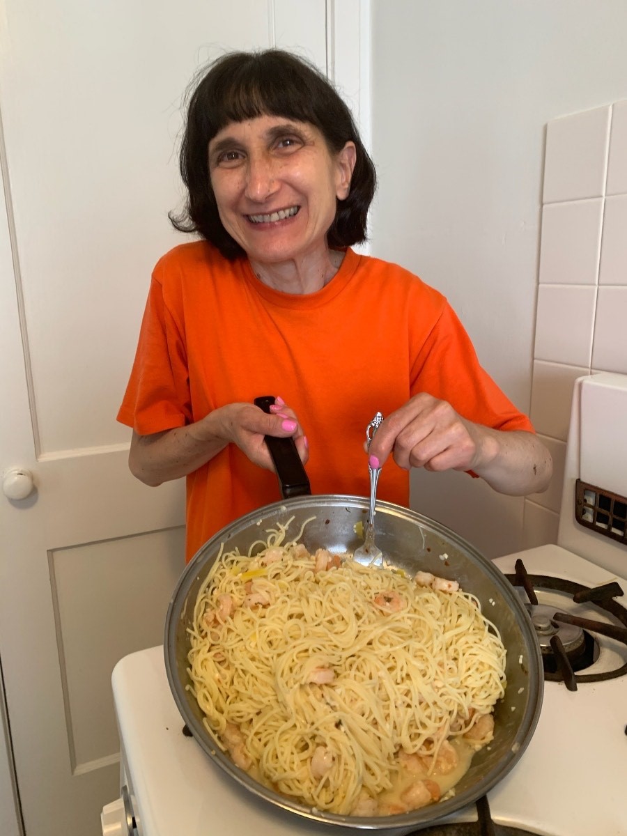 A woman we support displays the pasta she made
