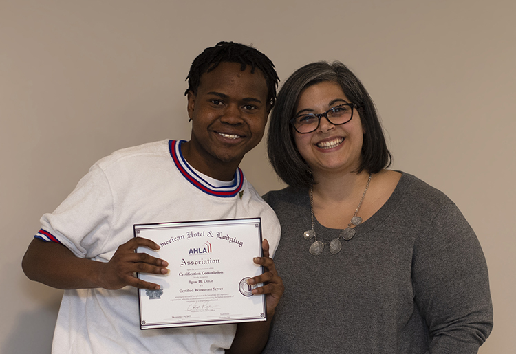 A young man poses with an employee